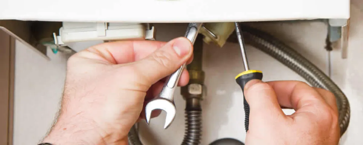 Boiler repair technician tightening pipe fittings and connections in Albany, NY