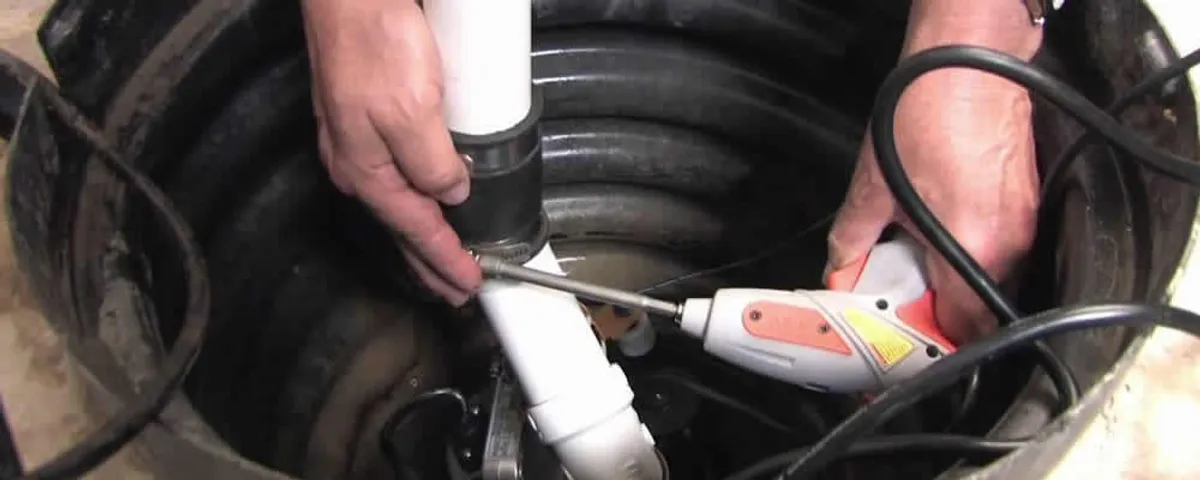 Sump pump installation technician connecting PVC discharge piping in Albany, NY